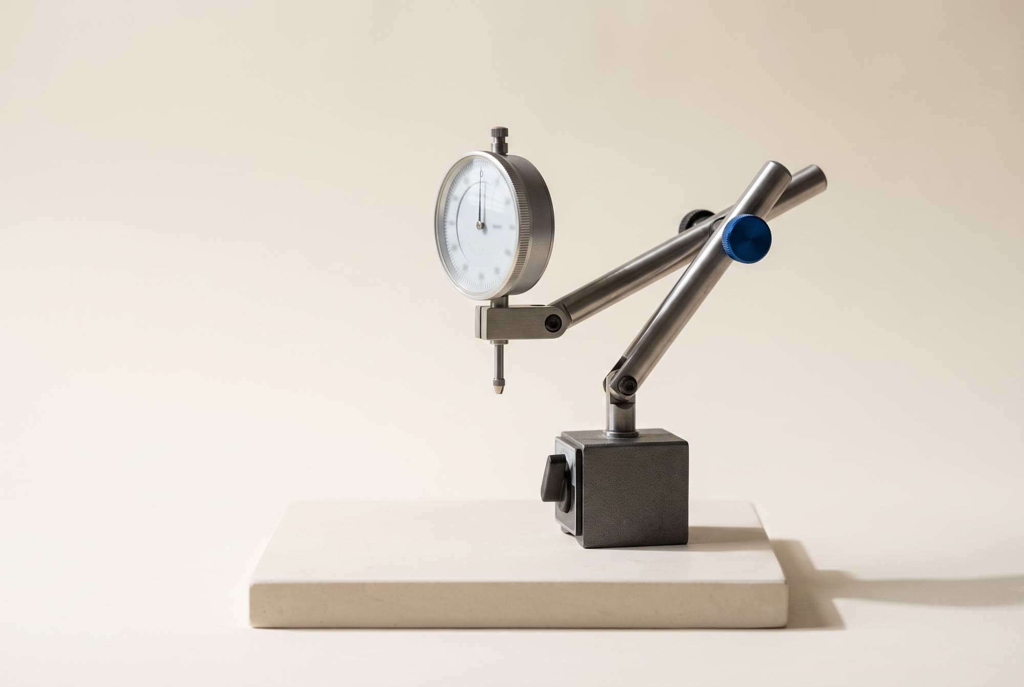 A precision dial test indicator on a stone plinth, its needle resting at zero